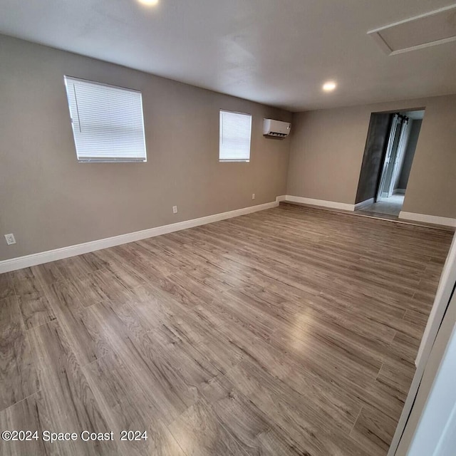 spare room featuring hardwood / wood-style floors and a wall mounted air conditioner