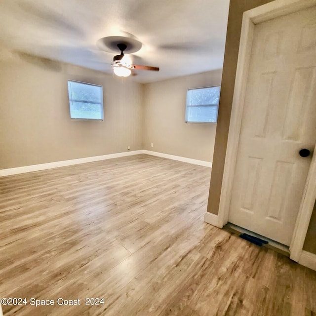 spare room featuring ceiling fan, a wealth of natural light, and light hardwood / wood-style floors