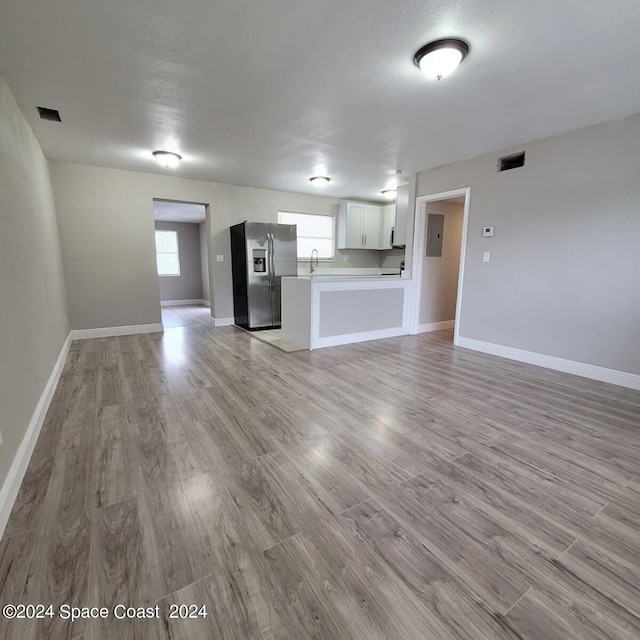 unfurnished living room with hardwood / wood-style floors and sink