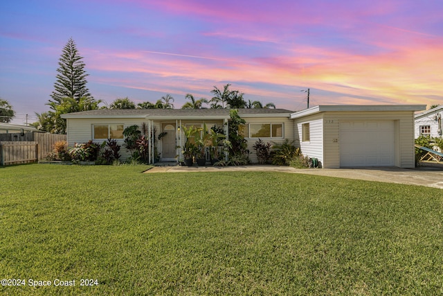 single story home featuring a garage and a yard