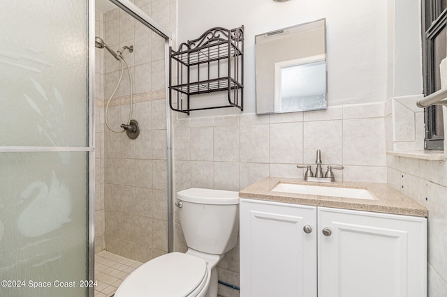 bathroom with toilet, a shower with door, vanity, tasteful backsplash, and tile walls