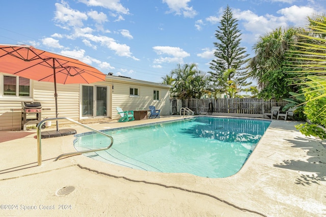 view of swimming pool with a fenced in pool, a patio, a grill, and fence