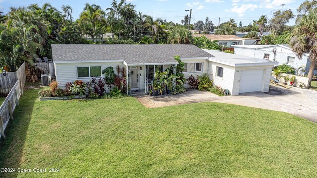 view of front of property with a garage, a front lawn, and central AC