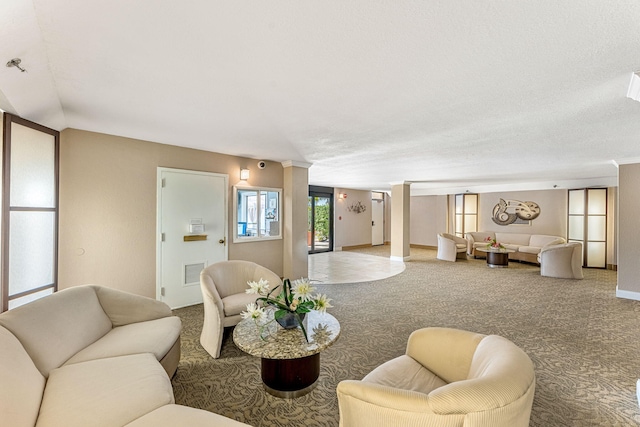 living room with a textured ceiling, carpet flooring, and ornate columns