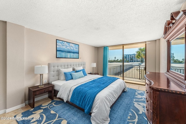 tiled bedroom featuring a textured ceiling, access to exterior, and multiple windows