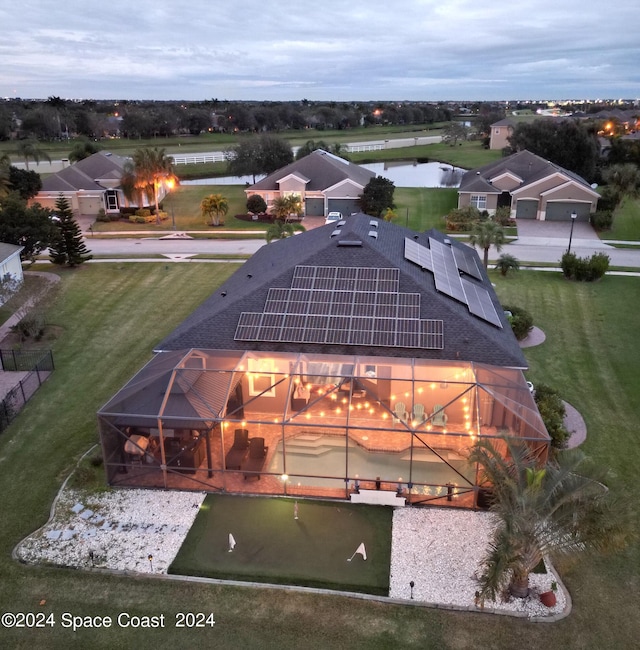 aerial view at dusk featuring a water view