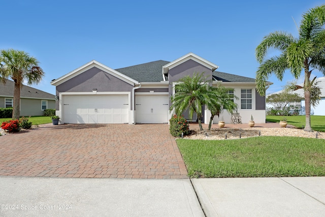 single story home featuring a front lawn and a garage