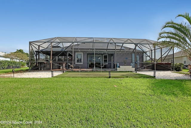 rear view of house featuring a lanai and a lawn