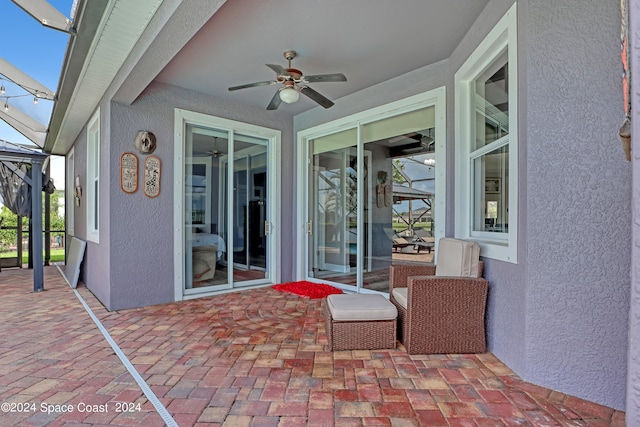 view of patio featuring glass enclosure and ceiling fan