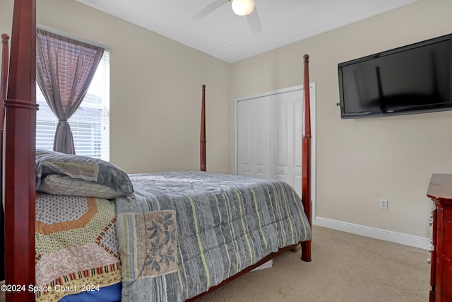 bedroom with ceiling fan, a closet, and light colored carpet