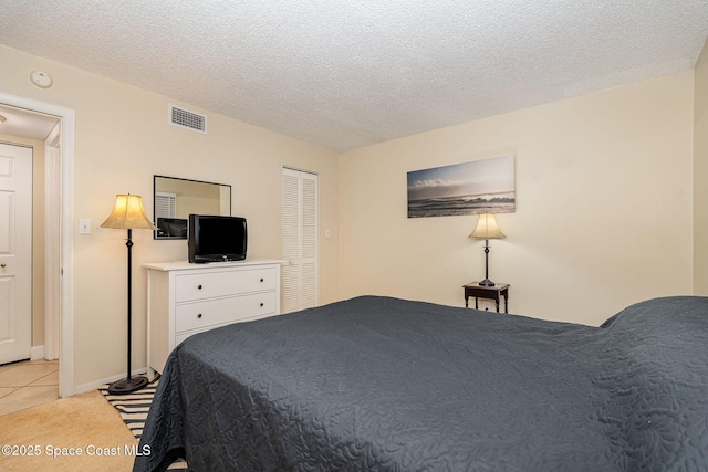 carpeted bedroom featuring a closet and a textured ceiling