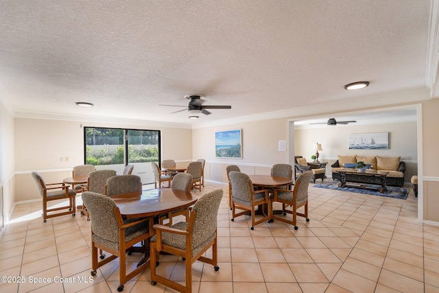 dining area featuring ceiling fan, a textured ceiling, crown molding, and light tile patterned flooring