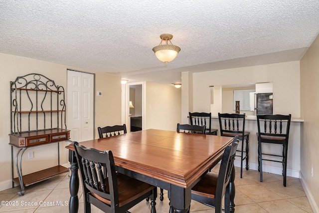 tiled dining area featuring a textured ceiling