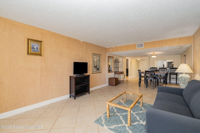 tiled living room featuring a textured ceiling