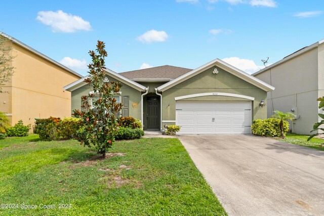 ranch-style home featuring a garage and a front lawn