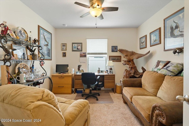 office space featuring light carpet and ceiling fan