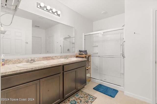 bathroom with tile patterned floors, a shower with shower door, and vanity