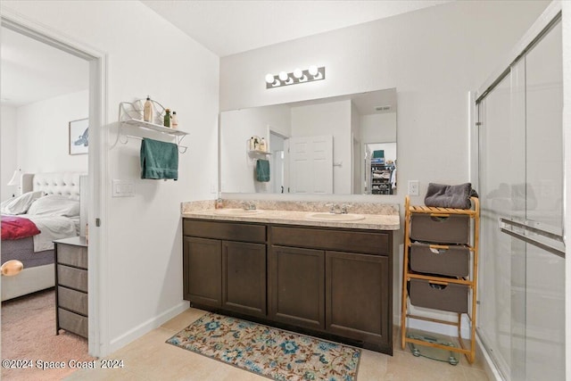 bathroom featuring tile patterned flooring, walk in shower, and vanity