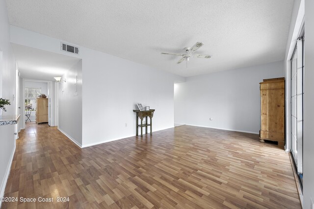 unfurnished room featuring ceiling fan, a textured ceiling, and hardwood / wood-style floors