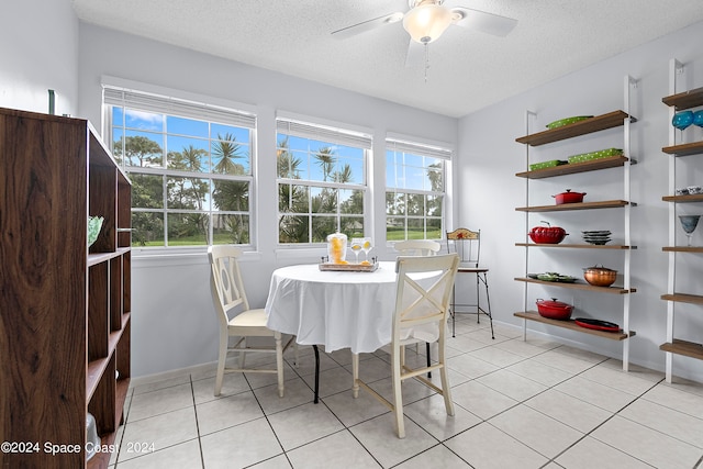 dining space with a textured ceiling, light tile patterned floors, and a wealth of natural light