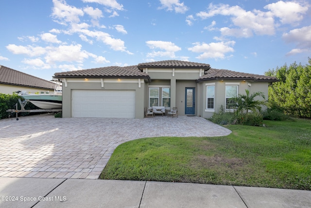 mediterranean / spanish house featuring a garage and a front yard