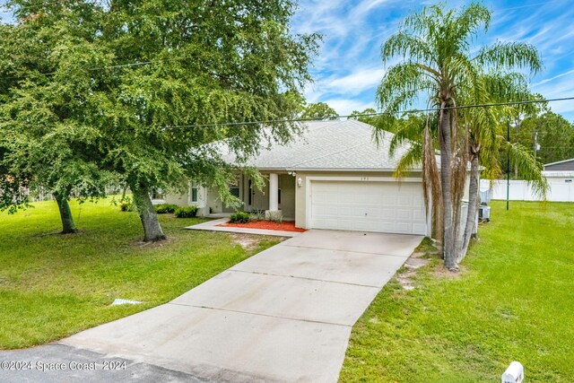 view of front of property featuring a front lawn and a garage