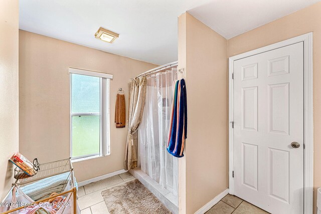 bathroom with a shower with curtain and tile patterned floors