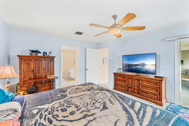 bedroom featuring a textured ceiling, ceiling fan, and ensuite bath