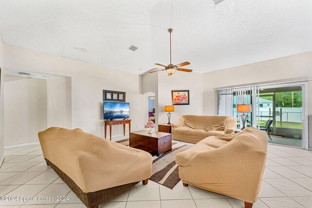 tiled living room featuring a textured ceiling and ceiling fan