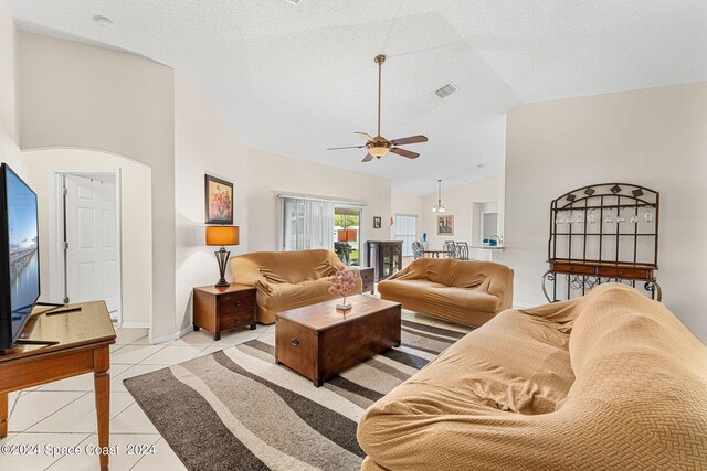 living room featuring a textured ceiling, ceiling fan, light tile patterned floors, and high vaulted ceiling