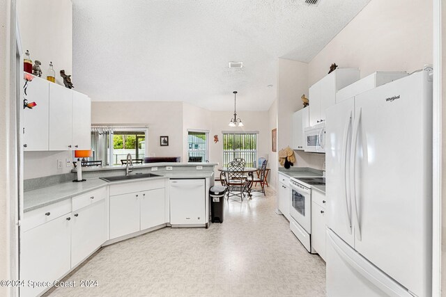 kitchen featuring white cabinets, decorative light fixtures, white appliances, sink, and kitchen peninsula