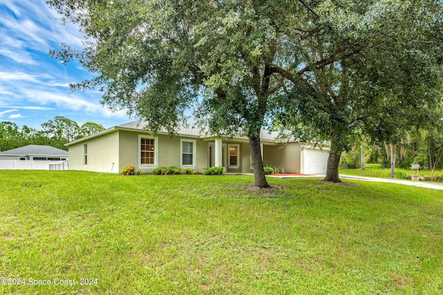 ranch-style house featuring a front lawn and a garage