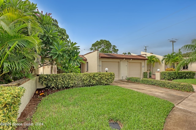 view of front of property featuring a garage and a front lawn