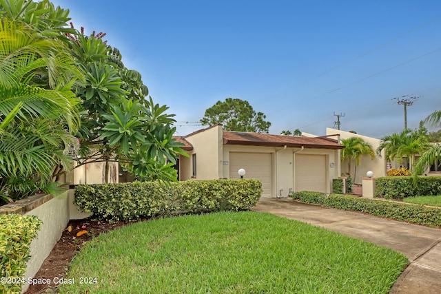 view of front of property with a garage and a front lawn