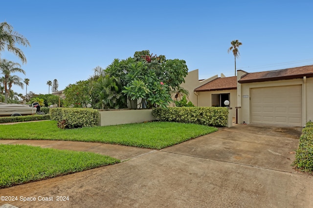 view of front of house with a garage and a front lawn