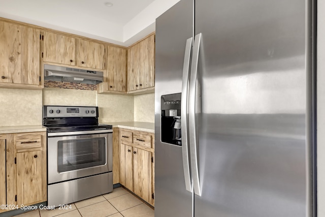 kitchen with stainless steel appliances, light brown cabinets, and light tile patterned flooring