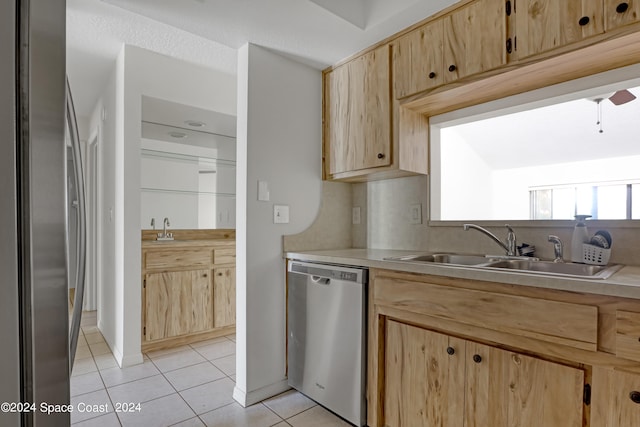 kitchen with dishwasher, light tile patterned floors, light brown cabinetry, and sink