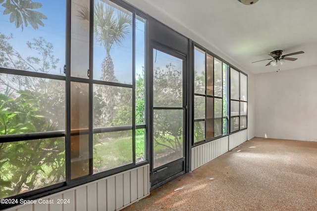 unfurnished sunroom with ceiling fan