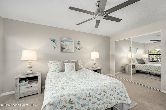 bedroom featuring a closet, ceiling fan, light carpet, and a textured ceiling