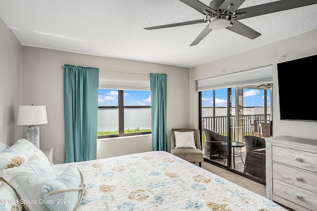 bedroom with a textured ceiling, ceiling fan, and access to outside