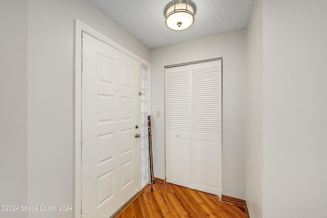 entryway featuring a textured ceiling and light hardwood / wood-style flooring