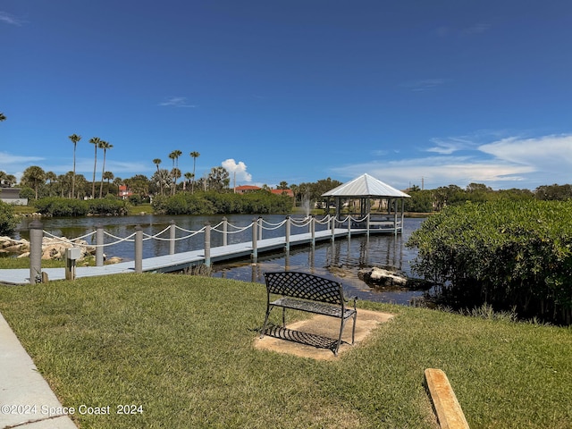 dock area with a water view, a lawn, and a gazebo