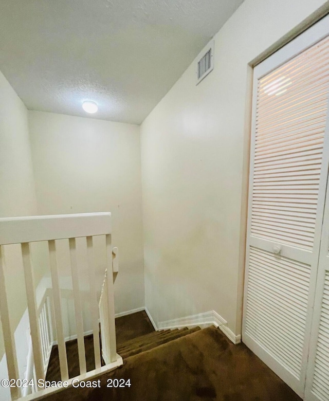 staircase with a textured ceiling