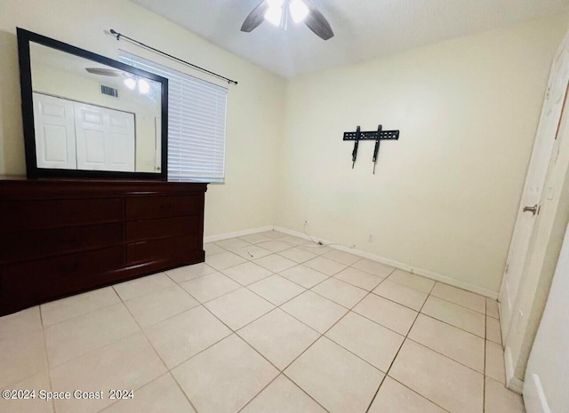 tiled spare room with ceiling fan