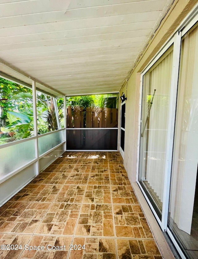 unfurnished sunroom featuring wood ceiling