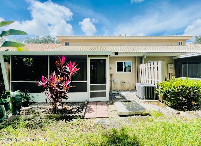 back of property with a sunroom and central air condition unit