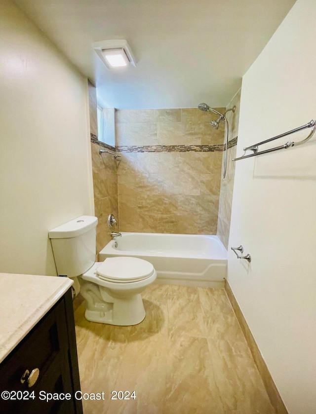 full bathroom with tiled shower / bath, vanity, and toilet