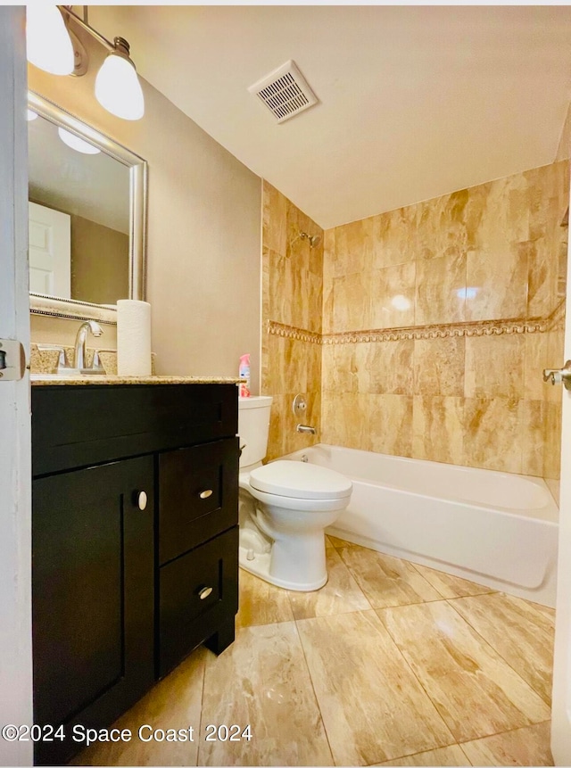 full bathroom featuring tiled shower / bath combo, vanity, and toilet