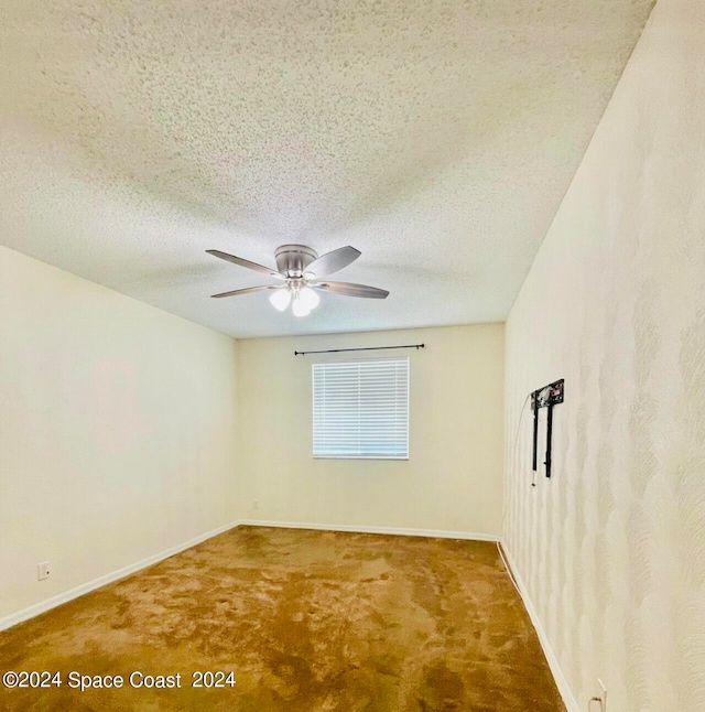 carpeted empty room featuring ceiling fan and a textured ceiling