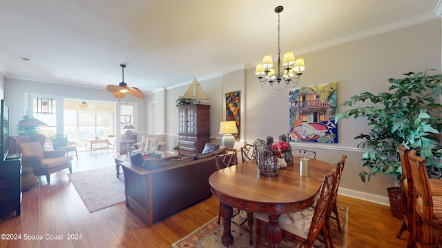 dining space featuring an inviting chandelier, ornamental molding, and dark hardwood / wood-style flooring